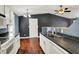 Kitchen features white cabinets, hardwood floors, stainless steel sink, and black counters at 251 Yorktown Rd, Greenwood, IN 46142