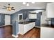 Open kitchen with white cabinets and modern appliances with hardwood flooring and view to living room at 251 Yorktown Rd, Greenwood, IN 46142