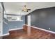 Open-concept living room with hardwood floors and a ceiling fan, flowing into the kitchen at 251 Yorktown Rd, Greenwood, IN 46142