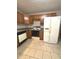 Well-lit kitchen featuring oak cabinets, tile floors, and a white side-by-side refrigerator at 2629 Calabash Dr, Indianapolis, IN 46217