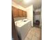 A laundry room featuring a white washer and dryer with oak cabinets above, with tile floors at 2629 Calabash Dr, Indianapolis, IN 46217
