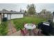Large backyard with a patio, grill, dining set and green grass, enclosed by a tall wooden fence at 2650 Woodrow Ave, Indianapolis, IN 46241