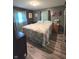 A quaint bedroom with gray walls, wood flooring, and large bed featuring bright, floral patterned bedding at 2650 Woodrow Ave, Indianapolis, IN 46241