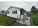 Charming home with white siding, black shutters, and manicured lawn, secured by a chain-link fence at 2650 Woodrow Ave, Indianapolis, IN 46241