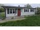 Charming single-story home with a red front door, black shutters, and manicured landscaping at 2650 Woodrow Ave, Indianapolis, IN 46241