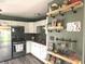 Modern kitchen with stainless steel appliances, white cabinets, and rustic shelving for added charm at 2650 Woodrow Ave, Indianapolis, IN 46241