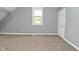 Neutral bedroom with gray walls, carpeted floors, bright lighting, and white paneled doors at 344 N Addison St, Indianapolis, IN 46222