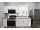 Updated kitchen with white cabinets, granite countertops, and stainless steel appliances at 344 N Addison St, Indianapolis, IN 46222