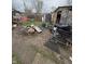 Untidy backyard filled with discarded materials and waste, including garbage bags and an old shopping cart at 3742 S Walcott St, Indianapolis, IN 46227