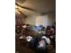 View of the cluttered living room, featuring a ceiling fan, a window, a couch and a side table at 3742 S Walcott St, Indianapolis, IN 46227