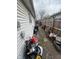 Side yard with a narrow pathway cluttered with items. The area needs decluttering and cleaning at 3742 S Walcott St, Indianapolis, IN 46227