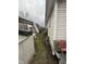 Untidy narrow yard space with discarded windows, chairs, and various debris along the side of the house at 3742 S Walcott St, Indianapolis, IN 46227
