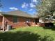 Spacious backyard featuring a well-kept lawn, brick exterior, and inviting covered porch at 379 Vinewood N Dr, Brownsburg, IN 46112
