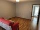 Simple room with wood floors, neutral walls, a pink patterned couch, and a view to the front door at 379 Vinewood N Dr, Brownsburg, IN 46112
