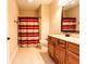 Bathroom featuring wood cabinets, a shower with a striped curtain, and tile flooring at 4061 Melbourne Dr, Columbus, IN 47203