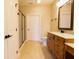Well-lit bathroom with a shower, tiled floor, and wooden vanity with granite countertop at 4061 Melbourne Dr, Columbus, IN 47203