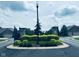 Welcoming community entrance featuring a decorative median with lush landscaping and a classic streetlight at 4061 Melbourne Dr, Columbus, IN 47203