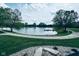 Picturesque community pond featuring a dock, bordered by lush green grass and paved walking paths at 4061 Melbourne Dr, Columbus, IN 47203