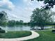 Scenic community pond with a small dock and walking path, surrounded by manicured lawns at 4061 Melbourne Dr, Columbus, IN 47203