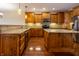 Well-equipped kitchen with granite countertops, wood cabinets, island, and stainless steel appliances at 4061 Melbourne Dr, Columbus, IN 47203