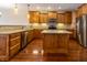 Well-lit kitchen with wood cabinets, granite countertops, island, and stainless steel appliances at 4061 Melbourne Dr, Columbus, IN 47203