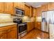 Well-lit kitchen features wooden cabinets, granite countertops, and stainless steel appliances at 4061 Melbourne Dr, Columbus, IN 47203