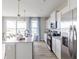 A well-lit modern kitchen features an island, stainless steel appliances, white cabinets, and a sliding glass door at 4722 E Shadowbrook Dr, Camby, IN 46113