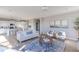 Open-concept living room with hardwood floors, a stylish rug, comfortable seating, and a view into the kitchen at 4722 E Shadowbrook Dr, Camby, IN 46113