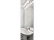 Bathroom with a pedestal sink, large mirror, and modern lighting at 4948 Potomac Square Pl, Indianapolis, IN 46268
