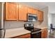 Efficient kitchen with wood cabinets, laminate countertops, and modern stainless steel appliances at 4948 Potomac Square Pl, Indianapolis, IN 46268