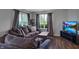 Inviting living room featuring hardwood floors, gray sofas, and a large screen TV at 4948 Potomac Square Pl, Indianapolis, IN 46268