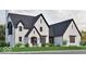 Charming white brick home with a dark roof and black trim, complemented by lush green landscaping at 5488 Stonewood Ct, Bargersville, IN 46106