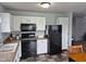 Functional kitchen featuring white cabinets, black appliances, and tile flooring at 5703 Wood Hollow Dr, Indianapolis, IN 46239