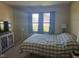 Well-lit bedroom with a large bed, window with blinds, and neutral carpet at 5703 Wood Hollow Dr, Indianapolis, IN 46239