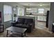 Comfortable living room with dark sofa, leading into an adjacent kitchen area at 5703 Wood Hollow Dr, Indianapolis, IN 46239