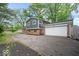 View of the home's exterior showcasing the attached garage, brick accents, and driveway leading to the side entrance at 5719 Laurel Hall Dr, Indianapolis, IN 46226