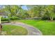 Large backyard featuring well-maintained lawn, concrete patio, basketball hoop, and wood fence at 6340 Monitor Ln, Indianapolis, IN 46220