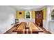 Yellow dining room featuring a wooden table, a window, and white brick paneling at 6340 Monitor Ln, Indianapolis, IN 46220