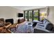 Living room features large windows, a gray sofa, leather chair, brick wall and hardwood floors at 6340 Monitor Ln, Indianapolis, IN 46220