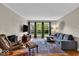 Comfortable living room with a gray sofa, leather chair, stylish rug and lots of natural light at 6340 Monitor Ln, Indianapolis, IN 46220