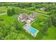 Aerial view showcasing a luxury home with a large pool, patio, and well-maintained grounds at 6990 Old Hunt Club Rd, Zionsville, IN 46077