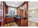 Wet bar featuring dark wood cabinetry, granite countertops and trim lighting at 6990 Old Hunt Club Rd, Zionsville, IN 46077