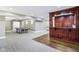 Finished basement showcasing bar area with dark wood trim, ping pong table and both carpet and wood floors at 6990 Old Hunt Club Rd, Zionsville, IN 46077