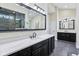 Elegant bathroom with double vanities, a large mirror, and sleek black cabinets and hardware at 6990 Old Hunt Club Rd, Zionsville, IN 46077
