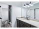 Modern bathroom features wood-look floors, a dark wood vanity, light countertops and a large mirror with stylish light fixture at 6990 Old Hunt Club Rd, Zionsville, IN 46077