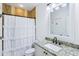 Well-lit bathroom with granite countertop, white sink, and decorative shower curtain, providing a relaxing and functional space at 6990 Old Hunt Club Rd, Zionsville, IN 46077
