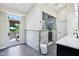 Modern bathroom featuring a glass-enclosed shower, double vanity, and access to the outdoor patio at 6990 Old Hunt Club Rd, Zionsville, IN 46077