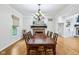 Dining room featuring hardwood floors, chandelier lighting, and a view of the fireplace at 6990 Old Hunt Club Rd, Zionsville, IN 46077