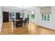 Bright dining area featuring a modern chandelier, large windows with outdoor views, and stylish dark wood sliding doors at 6990 Old Hunt Club Rd, Zionsville, IN 46077