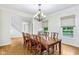 Elegant dining room with hardwood floors, decorative chandelier, and large windows overlooking the backyard at 6990 Old Hunt Club Rd, Zionsville, IN 46077